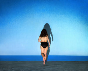 photo femme marchant sur l'eau avec son ombre se détachant sur le ciel